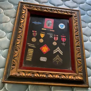 Military pins and dog tags in a frame