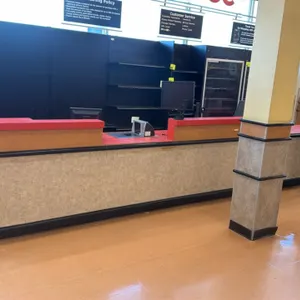 Laminate service counter with swing door. Features a red laminate countertop, transaction riser shelf, open under-counter cubby storage, bumper guard 