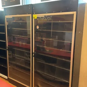 Metal lockable tobacco merchandisers. Features black metal cabinet construction, framed clear lockable display doors, and multi-tier product shelving.