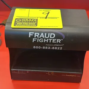 Fraud Fighter UV counterfeit bill detector. Features ultraviolet inspection lamps and integrated currency alignment verification guide on base. Includ