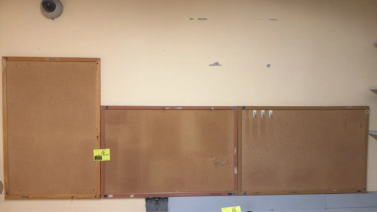 Wall-mounted cork boards. Features cork tack surfaces with assorted wood-tone and metal frames. 3' x 2' each.
