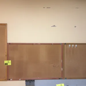 Wall-mounted cork boards. Features cork tack surfaces with assorted wood-tone and metal frames. 3' x 2' each.