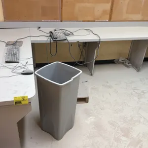 Laminate U-shaped countertop workstation with wall-mounted shelving. Features an integrated backsplash and a 3-tier adjustable wall shelving system wi