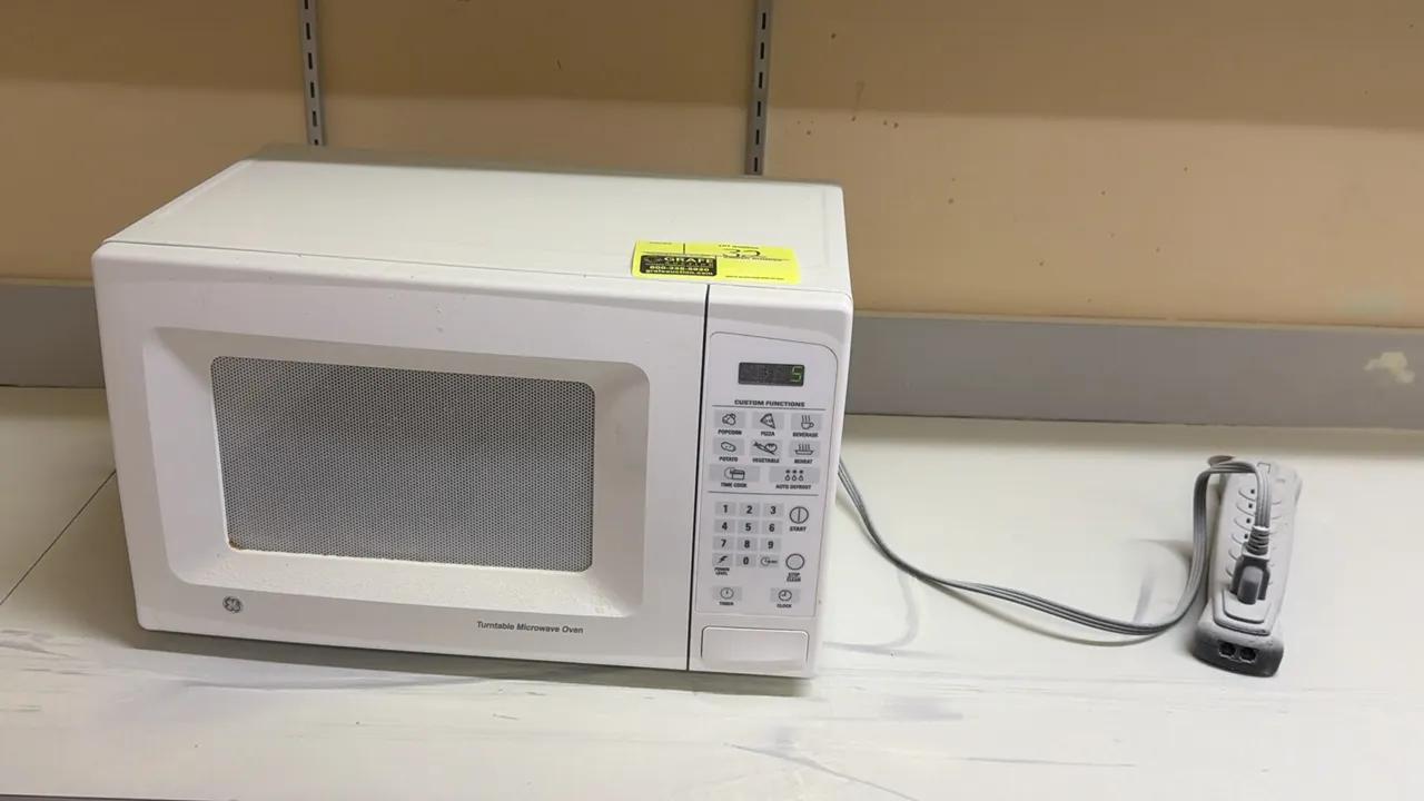 General Electric countertop microwave oven. Features digital touchpad controls, preset cooking options, and push-button door release. Electrical: 120V