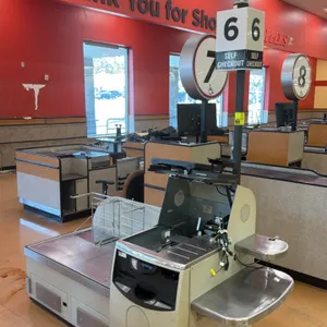 NCR 7350 self-checkout lane. Features stainless steel top, touchscreen monitor, overhead lane light pole, dual wire bag racks, and side shelves. 7'L. 
