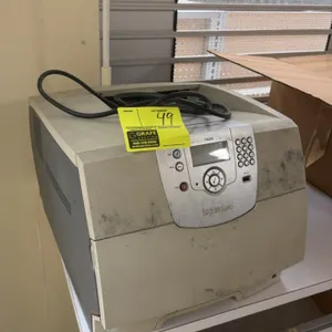 Lexmark T640 tabletop printer. Features a front control panel with LCD display, navigation keypad, front USB direct port, and integrated paper cassett