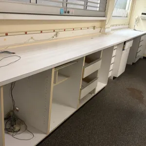 Laminate pharmacy countertop with integrated stainless steel sink. Features base cabinetry with drawers and open compartments, single-basin stainless 