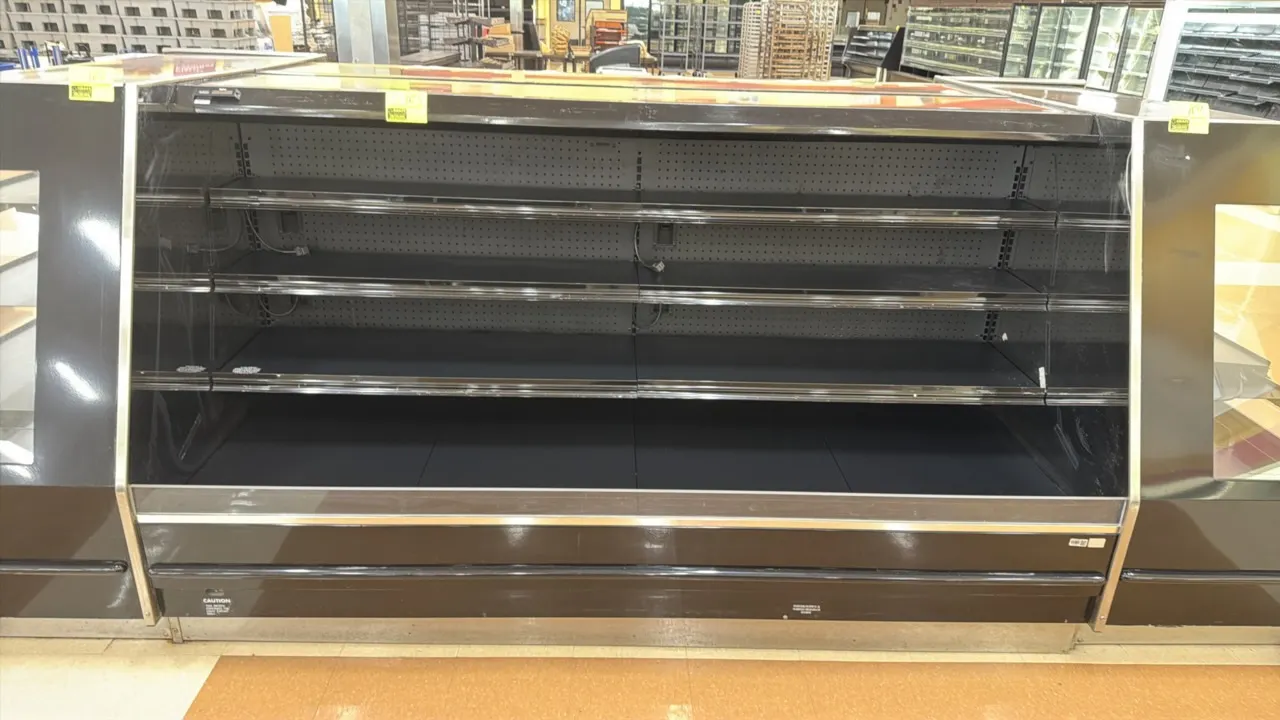 1998 Barker PF8R54 low-profile open refrigerated display case. Features 3 tiers of adjustable metal shelving, bottom display deck, glass side panels,