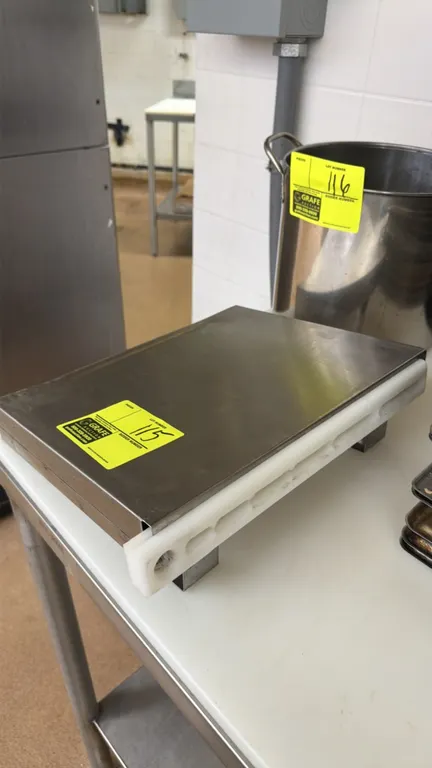 Wall-mount stainless steel knife block. Features a stainless steel housing, slotted white plastic knife insert, and rear mounting brackets.