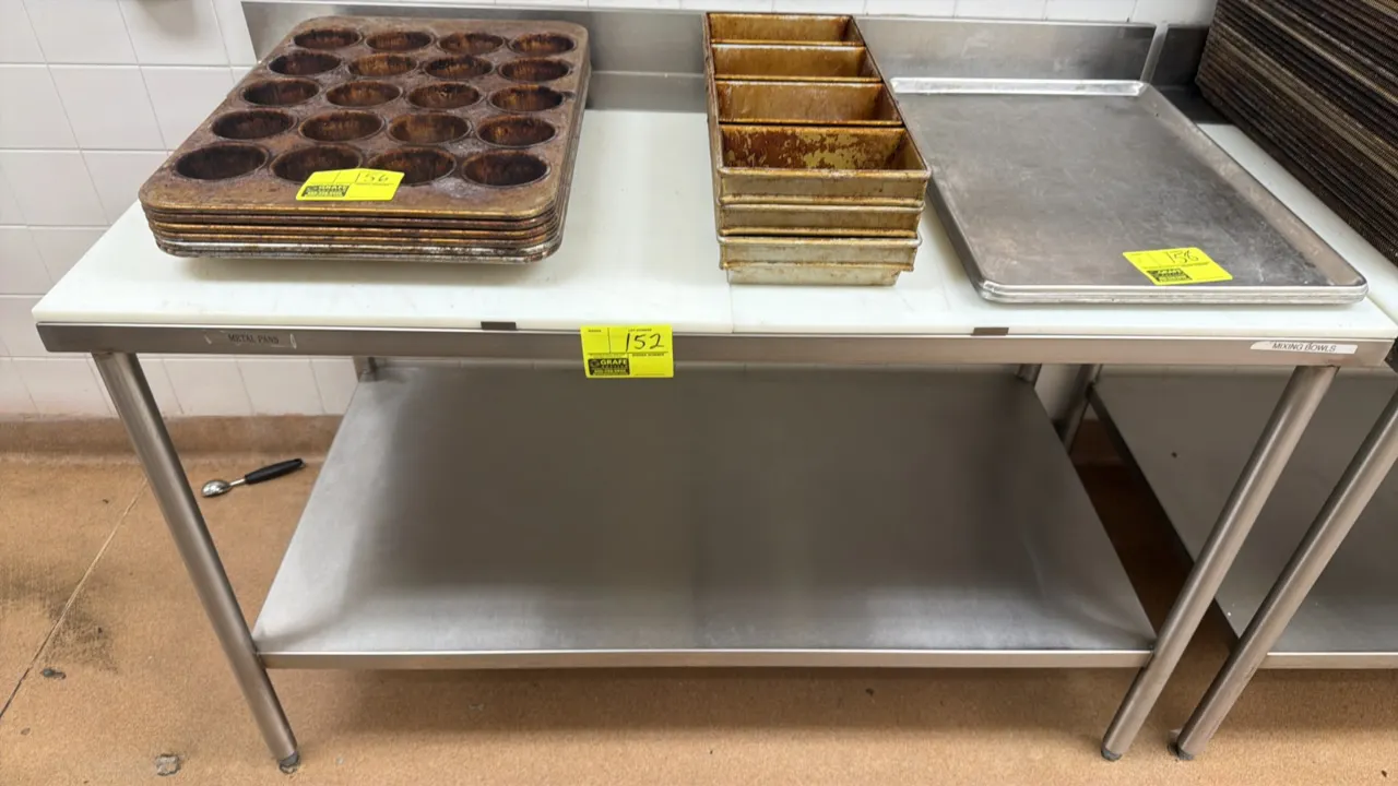Stainless steel prep table. Features a poly top cutting board surface, rear backsplash, and stainless steel undershelf. 5' x 2.5'. Mounted on tubular