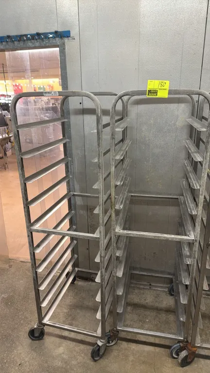 Winholt stainless steel front-load channel pan racks. Features angle slide runners and tubular frame construction. Mounted on swivel casters.