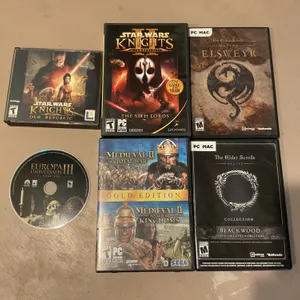 PC Game Discs and Cases Featuring RPG and Strategy Titles