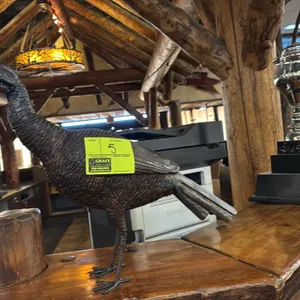 Metal wild turkey decorative sculpture. Features textured metal construction with detailed feather patterning and a dark bronze-tone finish. Freestand