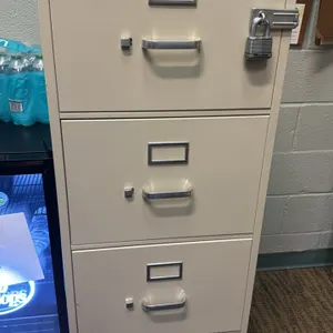 HON metal 4-drawer vertical file cabinet. Features a beige finish, pull handles, integrated label holders, top cylinder lock, and an installed exterio