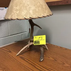 Rustic antler table lamp. Features an antler base design, whipstitched rawhide-style shade, and pull chain switch with antler-shaped pull. 23"H.