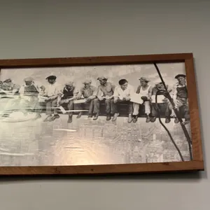 A "Lunch atop a Skyscraper" Framed Print. A framed reproduction print of the iconic 1932 photograph depicting eleven construction workers seated along