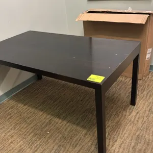 Black wooden table. Features a rectangular top and four square legs. Dimensions: 60"L x 34"W.