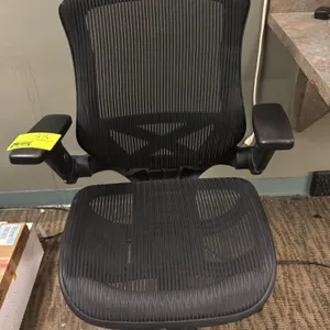 Mesh office chair. Features breathable black mesh seat and back, adjustable armrests, pneumatic height adjustment, and tilt tension control. Mounted o