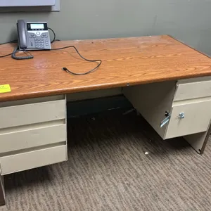 Metal double-pedestal desk with woodgrain laminate top. Features (3) left-side drawers and (2) right-side drawers fitted with exterior locking hasps. 