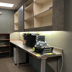 Laminate countertop with upper cabinet system. Features faux stone patterned laminate finish, matching backsplash, undercabinet task lighting, and upp