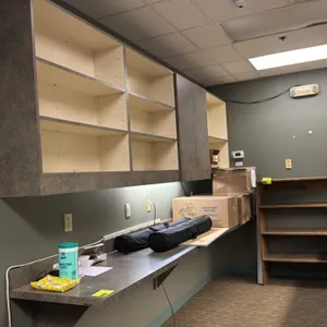 Laminate countertop with upper wall-mounted cabinets. Features a faux-stone laminate finish, wall-mounting support brackets, integrated backsplash, an