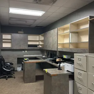Cash room laminate workstation with upper cabinets. Features faux-stone patterned laminate surfaces, lower drawer pedestals, open desk knee spaces, an