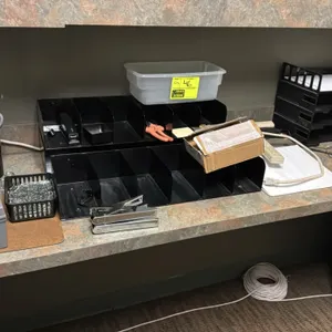 Package lot of assorted office supplies. Includes multi-compartment metal desk sorters, a 4-tier stacking letter tray, clear plastic bin, plastic kit 